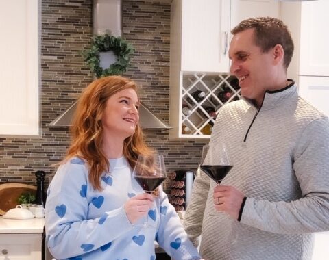Couple drinking red wine in kitchen for Valentine's Day